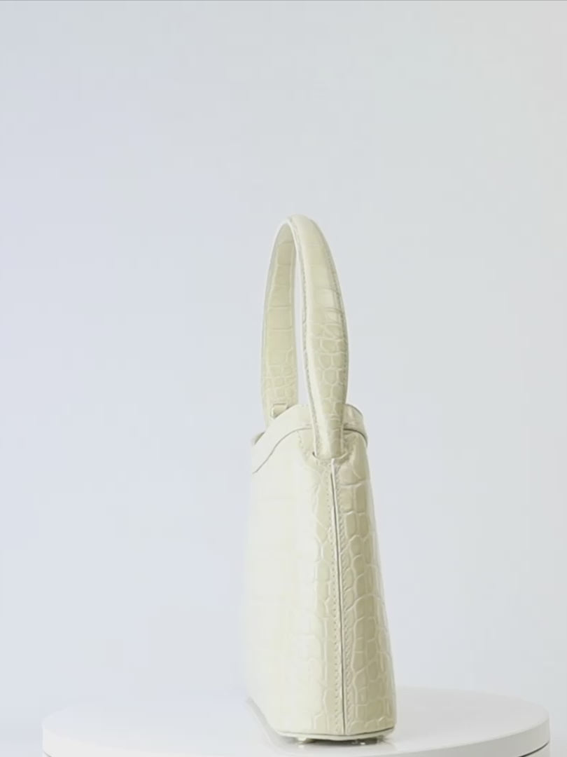 Gamberini Bag. Premium Italian calfskin leather. 18K gold-plated oval accessory. Hand-sewn embroidery.