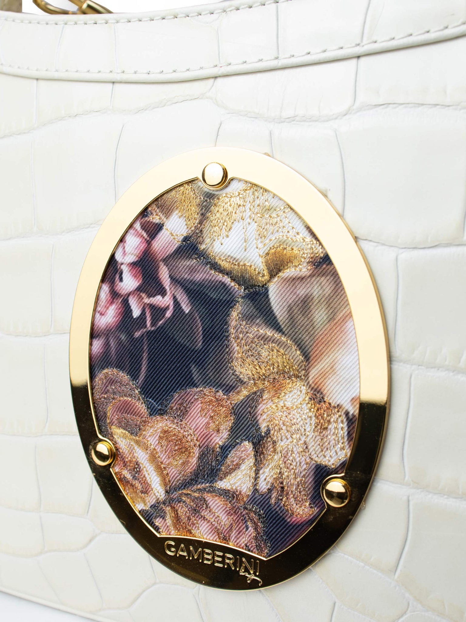 Gamberini Bag. Premium Italian calfskin leather. 18K gold-plated oval accessory. Hand-sewn embroidery. 