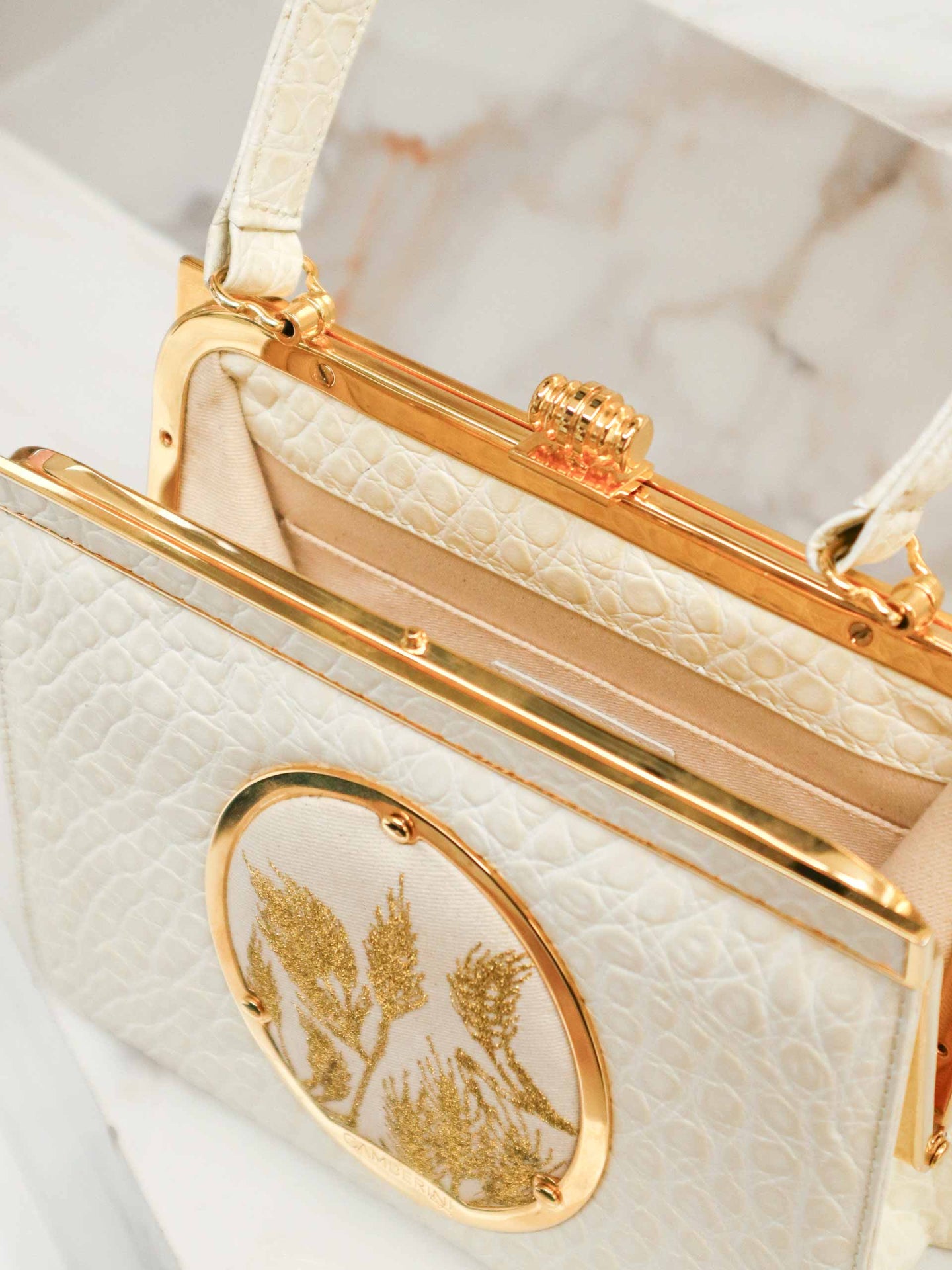 Maria Bag – Luxury Italian Handbag with Timeless Elegance. Traditional Italian craftsmanship with modern aesthetics.  18K gold-plated oval frame, adorned with hand embroidered golden wheat.